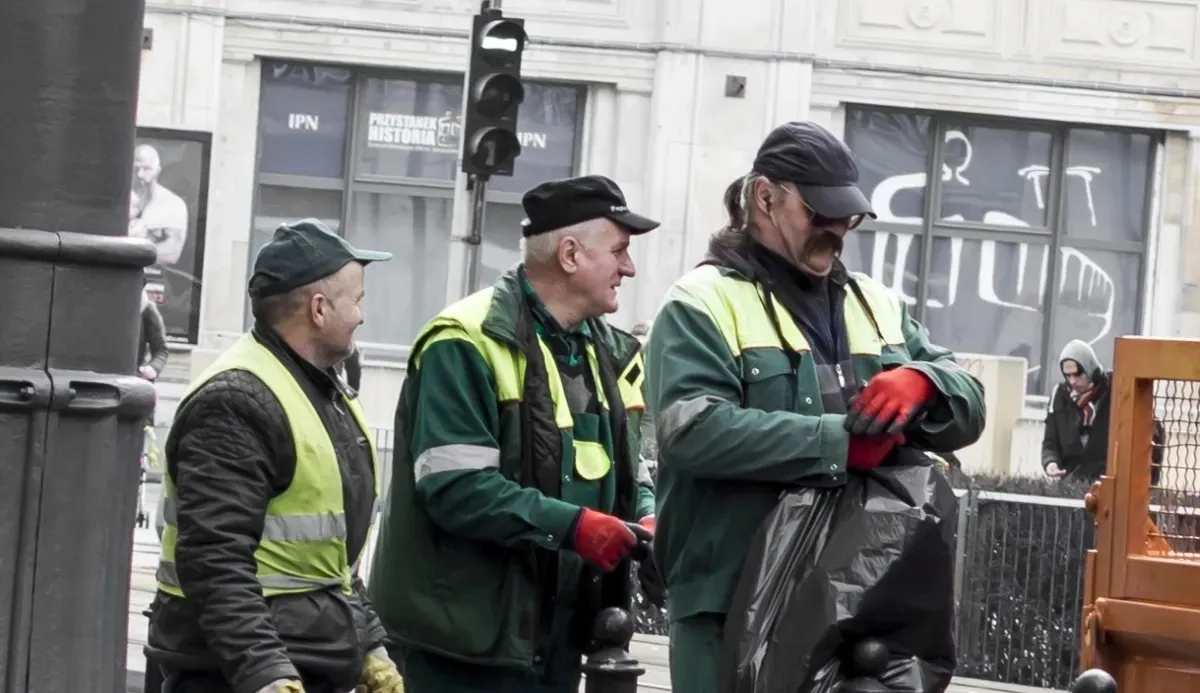 Three municipal workers chatting on a city street